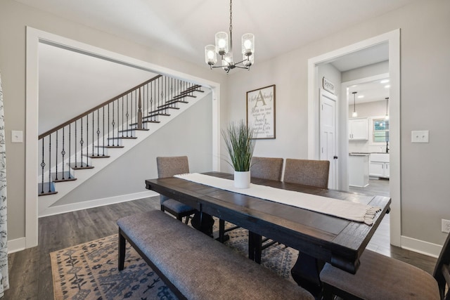 dining area with dark hardwood / wood-style floors and a chandelier