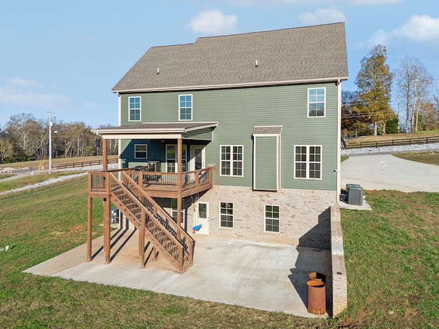 rear view of house featuring a lawn, a patio area, a wooden deck, and central AC