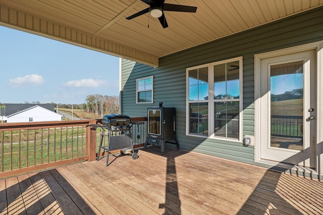 wooden terrace with ceiling fan and a grill