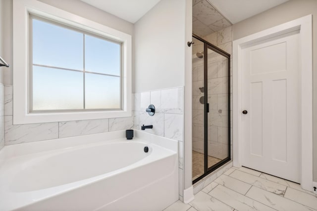 bathroom featuring independent shower and bath