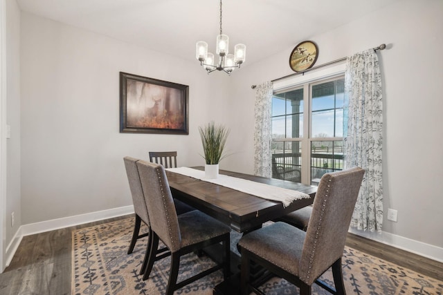 dining room with dark hardwood / wood-style flooring and an inviting chandelier