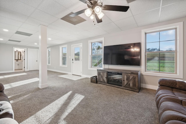 living room with carpet flooring, ceiling fan, and a drop ceiling