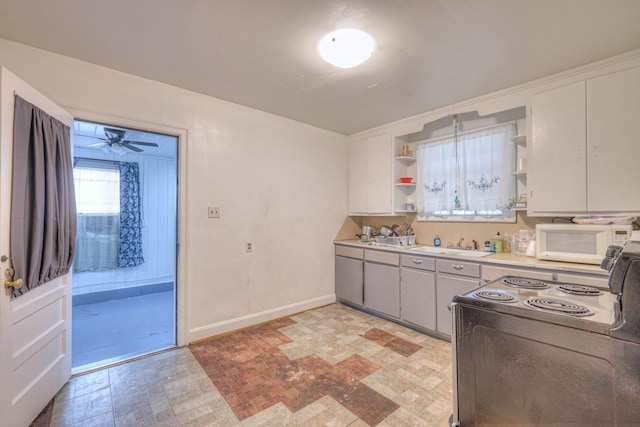 kitchen featuring ceiling fan, electric stove, and sink