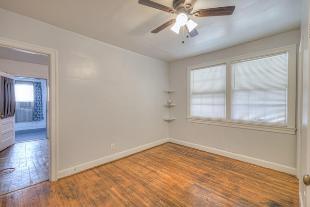 empty room with ceiling fan and dark hardwood / wood-style flooring