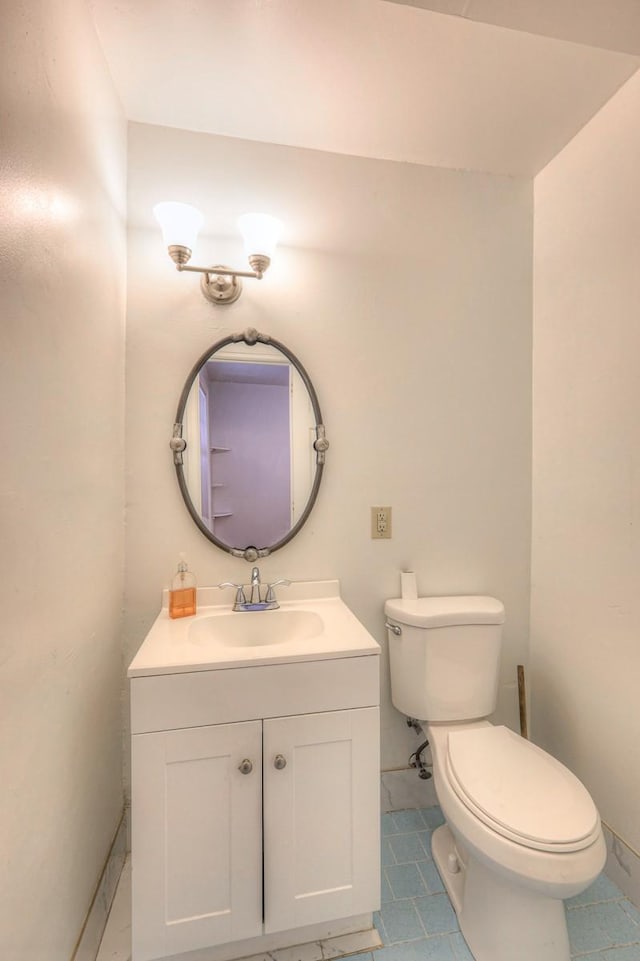 bathroom featuring tile patterned flooring, vanity, and toilet