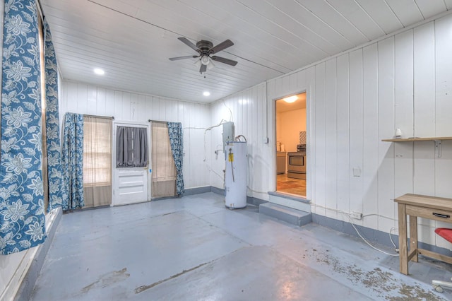 interior space with water heater, wooden walls, ceiling fan, and concrete floors