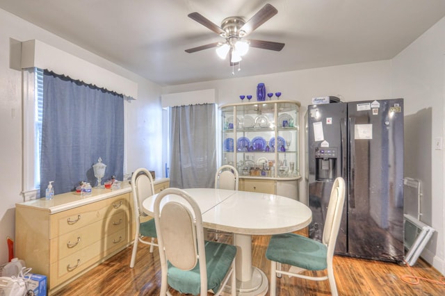 dining area featuring wood-type flooring and ceiling fan