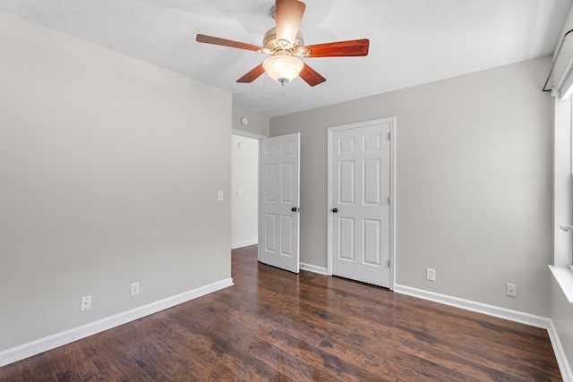 unfurnished bedroom featuring ceiling fan and dark hardwood / wood-style floors