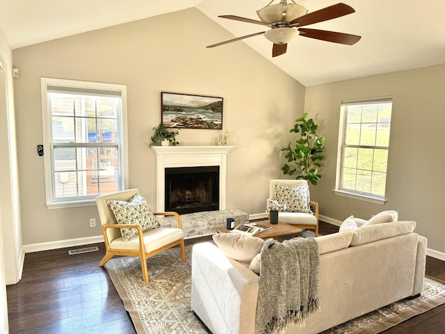 living room featuring dark hardwood / wood-style floors, ceiling fan, a fireplace, and a wealth of natural light