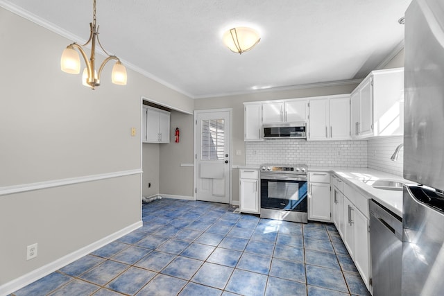 kitchen with backsplash, white cabinets, sink, decorative light fixtures, and stainless steel appliances