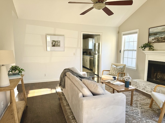 living room featuring ceiling fan, dark hardwood / wood-style flooring, vaulted ceiling, and a brick fireplace