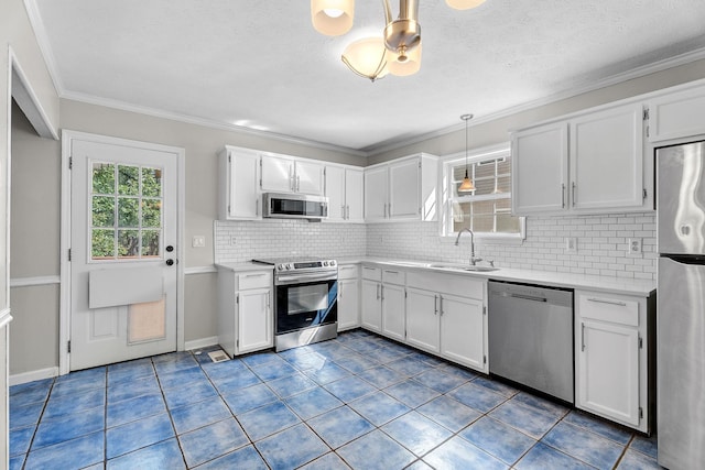 kitchen featuring white cabinets, stainless steel appliances, hanging light fixtures, and sink