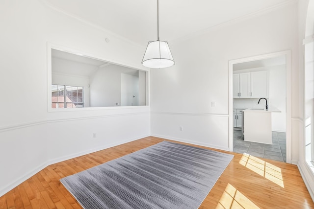 dining space with crown molding, sink, vaulted ceiling, and light wood-type flooring