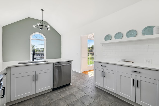 kitchen featuring white cabinetry, dishwasher, sink, lofted ceiling, and decorative light fixtures