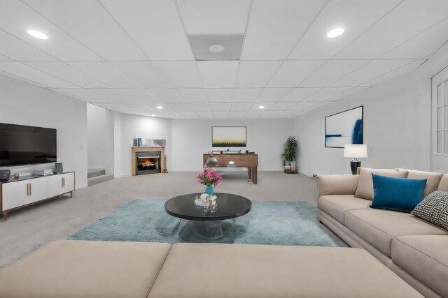 carpeted living room with a paneled ceiling