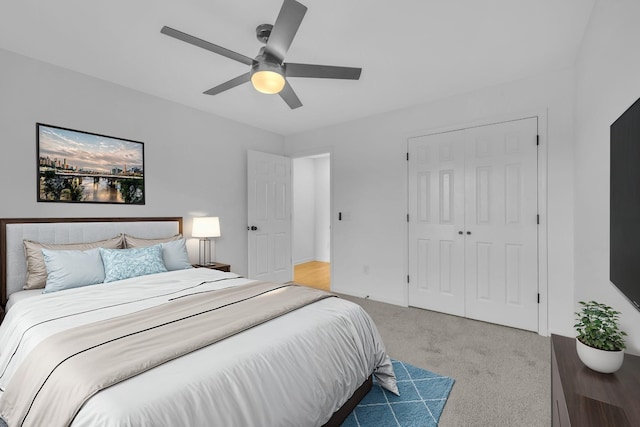 bedroom featuring ceiling fan, a closet, and light colored carpet