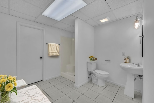 bathroom with tile patterned floors, a paneled ceiling, a shower, and toilet