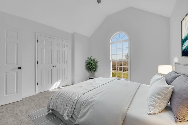 carpeted bedroom featuring ceiling fan, a closet, and vaulted ceiling