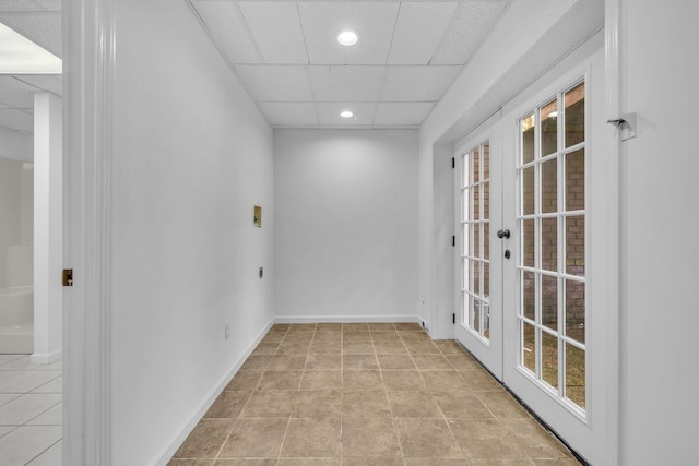 unfurnished room featuring a drop ceiling and french doors