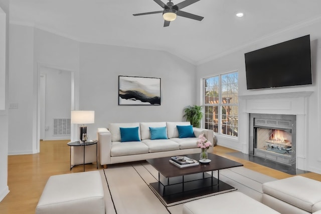 living room with ornamental molding, light hardwood / wood-style flooring, ceiling fan, and lofted ceiling