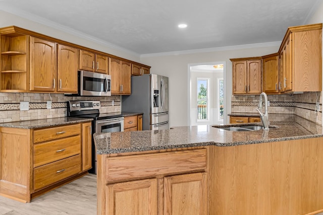 kitchen with sink, tasteful backsplash, kitchen peninsula, appliances with stainless steel finishes, and ornamental molding