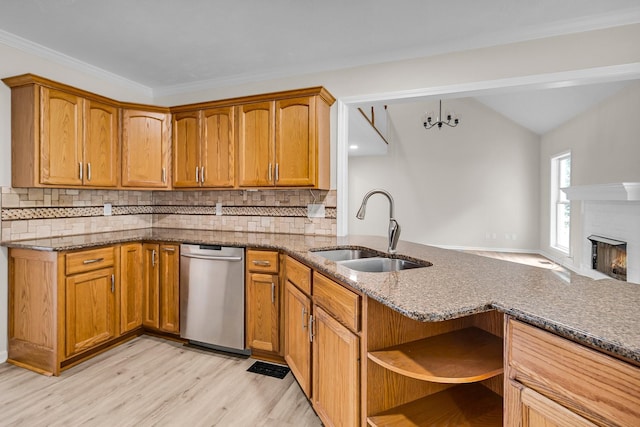 kitchen with backsplash, sink, stainless steel dishwasher, and stone countertops