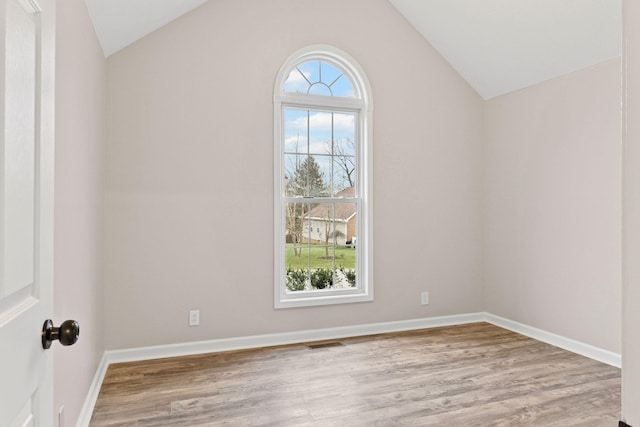 unfurnished room with a healthy amount of sunlight, light hardwood / wood-style flooring, and lofted ceiling