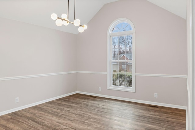 spare room with dark hardwood / wood-style floors, a chandelier, and lofted ceiling