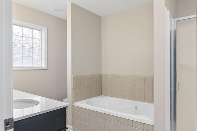 full bathroom with a textured ceiling, vanity, shower with separate bathtub, and toilet