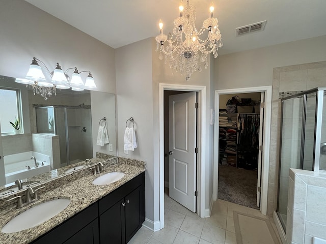 bathroom with tile patterned floors, vanity, separate shower and tub, and an inviting chandelier