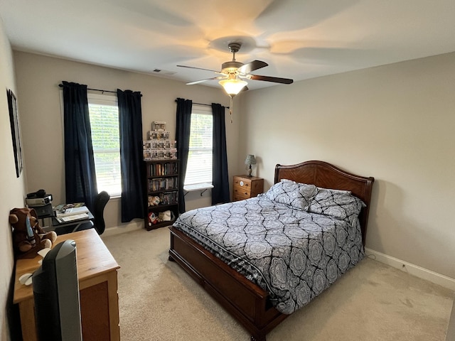 bedroom with ceiling fan and light carpet