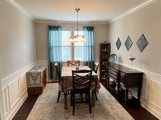 dining area featuring a chandelier, dark wood-type flooring, and ornamental molding