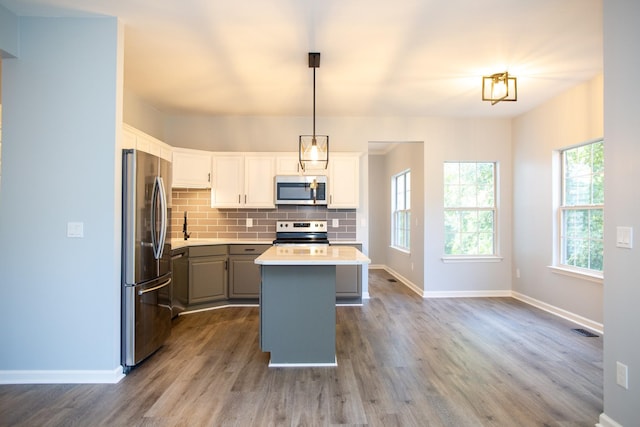 kitchen featuring gray cabinets, appliances with stainless steel finishes, pendant lighting, white cabinetry, and a center island