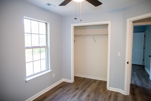 unfurnished bedroom featuring dark wood-type flooring, a closet, and ceiling fan