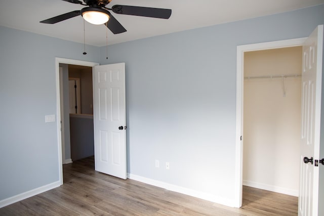 unfurnished bedroom with ceiling fan, light wood-type flooring, and a closet