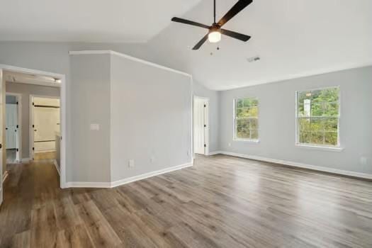 spare room with hardwood / wood-style flooring, vaulted ceiling, and ceiling fan