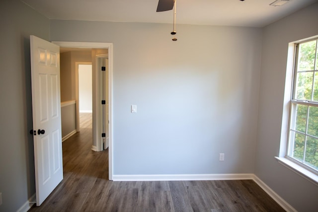 spare room with dark wood-type flooring and ceiling fan