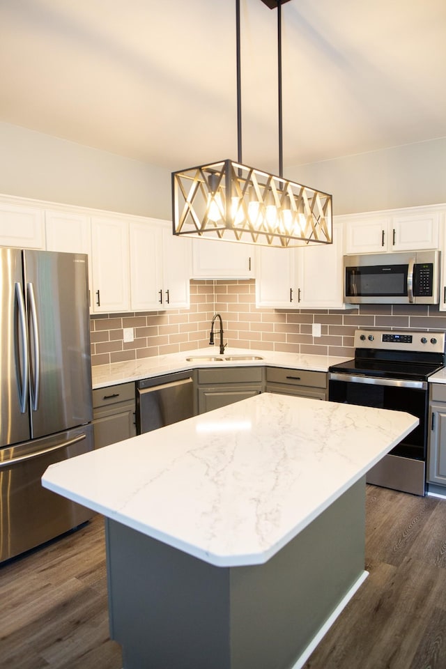 kitchen with pendant lighting, sink, a kitchen island, and appliances with stainless steel finishes