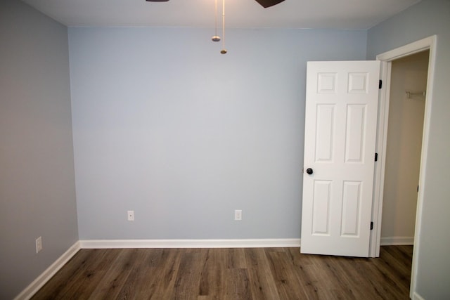 spare room with dark hardwood / wood-style flooring and ceiling fan