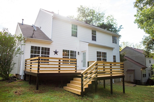 back of property with a wooden deck and a lawn