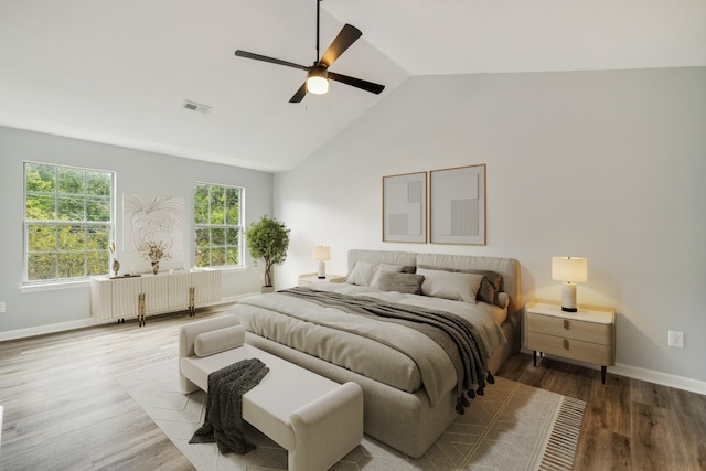 bedroom with ceiling fan, lofted ceiling, and wood-type flooring