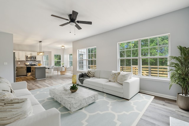 living room featuring ceiling fan and light hardwood / wood-style flooring