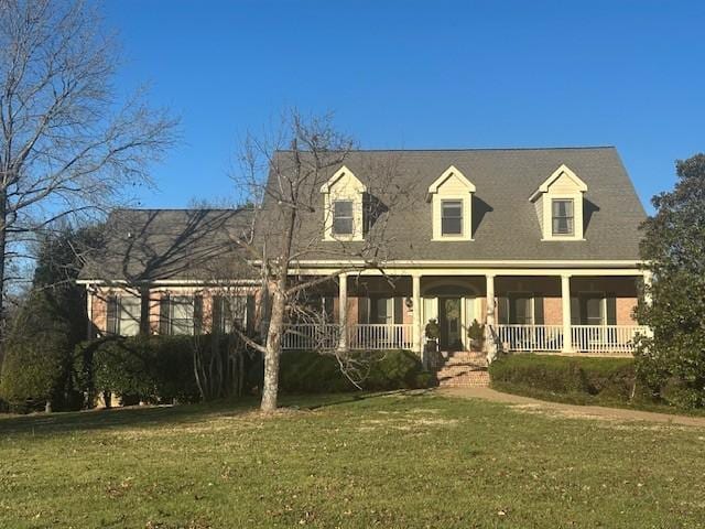 cape cod-style house with a front lawn and covered porch