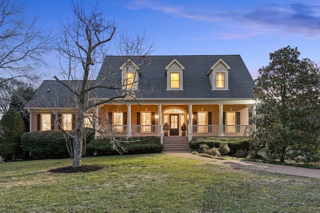 new england style home with a lawn and a porch