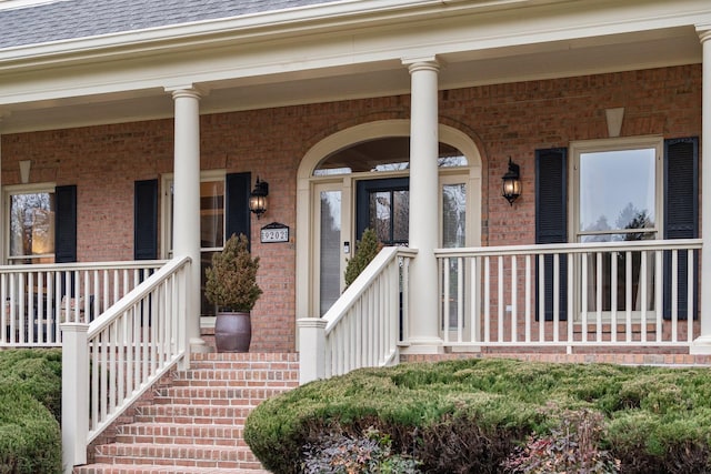 view of exterior entry featuring covered porch