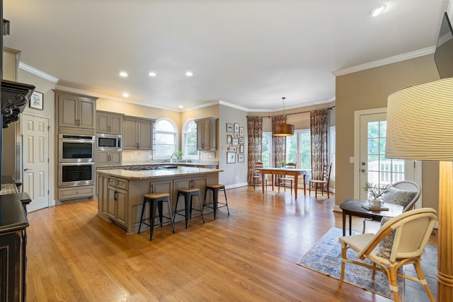 kitchen with a center island, light wood-type flooring, pendant lighting, stainless steel appliances, and light stone countertops