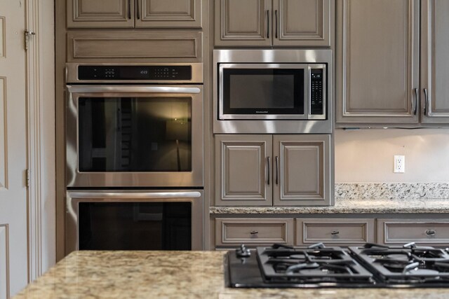 kitchen featuring light stone countertops and appliances with stainless steel finishes