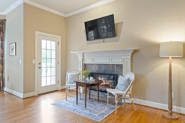 sitting room featuring ornamental molding, a fireplace, and light hardwood / wood-style floors