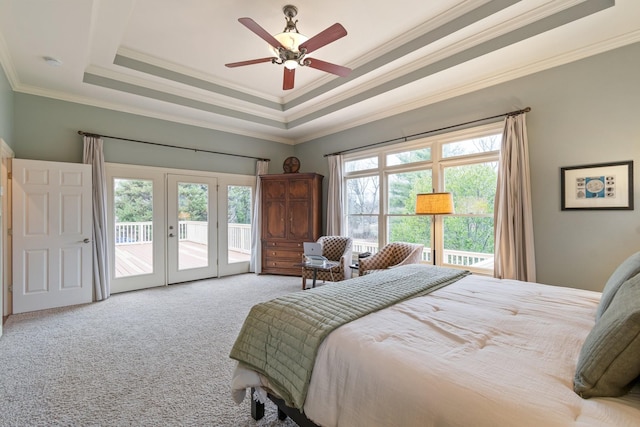 bedroom with a raised ceiling, access to outside, light colored carpet, and french doors