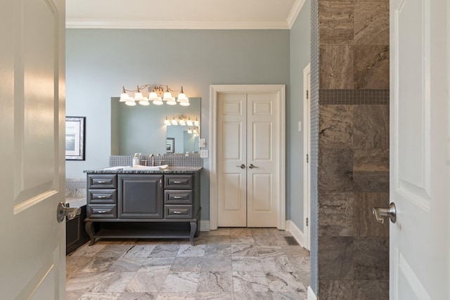 bathroom featuring vanity, ornamental molding, and a tile shower